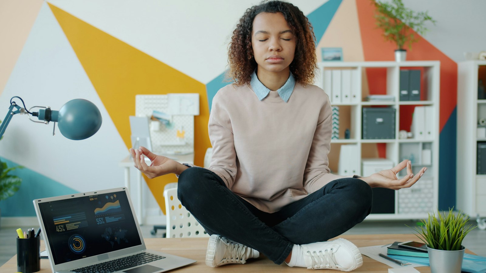 A woman at her desk taking a moment to breathe and stretch during the working day