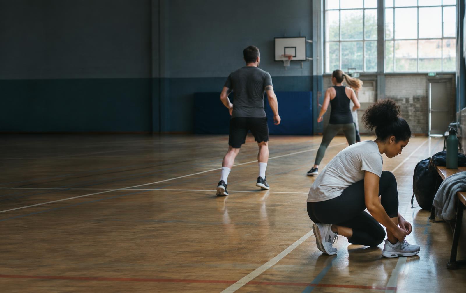 People preparing to play sport together in an indoor court